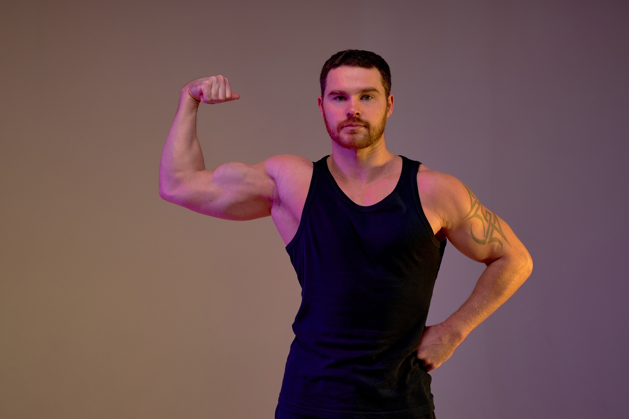 strong sporty toned sportsman wearing black sportswear spend time in gym